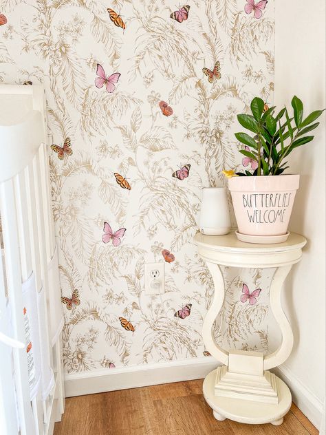 A beautiful nursery with butterfly wallpaper and neutral colors Butterfly Nursery Wallpaper, Butterfly Garden Nursery Theme, Wildflower Butterfly Nursery, Monarch Butterfly Nursery, Vintage Floral Room Aesthetic, Butterfly Garden Nursery, Butterfly And Flower Nursery, Baby Girl Nursery Butterflies, Boho Butterfly Nursery