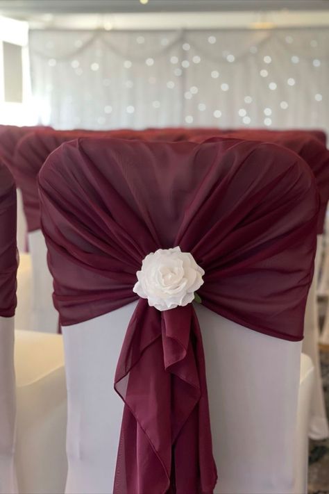 Burgundy Hood with a White Rose Clip Flower on a White Chair Cover Burgundy Wedding Chair Decor, Burgundy Chair Covers Wedding, Red Chair Decor, Wedding Chair Design, Wedding Chair Cover Ideas, Chair Covers Wedding Reception, Most Beautiful Wedding Venues, Diy Chair Covers, White Chair Covers