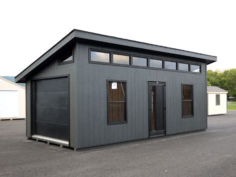 12x24 Lancaster Garage w Smart Panel T111 Siding - Modern Shed Collection- Pressure treated skids- 2x4 Pressure treated floor joists 8" O.C.- 3/4" Flooring- 2x4 walls 16" O.C.- 2x6 rafters 16" O.C.- 7&apos;1" high rear wall- 10&apos;1" high front wall- Mitered trim package- Two 30x54 Grid-less windows with screens- 7-35" Grid-less Transoms on front high wall- Two Trapezoids on gables- 3&apos;x78" Modern door- 9x7 Flush Panel Garage Door- 3/12 roof pitch- 1 Small Garage Bedroom Ideas, 12x24 Shed Plans Layout, Modern Garage Storage Ideas, Stand Alone Garage Ideas, Shed Layout Ideas, Single Car Garage Ideas, Modern Garage Design Interior, Shed Roof Garage, Modern Black Garage