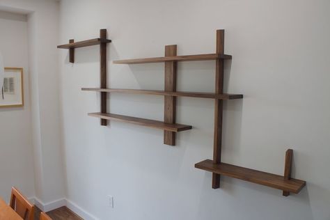 This asymmetrical, Japanese design inspired, dining room shelving was designed with the intention to display to our client’s favourite personal mementos. Made from walnut. It is fastened to the studs in the wall as well as held together with tight wood joinery. Japanese Shelves Design, Japanese Wall Shelves, Japanese Shelf Design, Japanese Shelving, Japanese Shelves, Asymmetrical Shelving, Japanese Shelf, Wood Bookshelf Wall, Interlocking Furniture