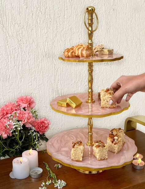 This gorgeous blush pink Dessert Stand will add an elegant and soft touch to your celebration.
It is handmade with a modern touch, by Indian artisans. It comprises of resin and aluminium.

Serve cakes, pastries, desserts, cupcakes, sweets, cookies or snacks.
This Dessert Stand personifies beauty, elegance, and richness.

Choose between a Two-Tier or a Three-Tier Stand.

Product Dimensions (approx):
Three Tier
Length: 30cm
Width: 30cm
Height: 51cm

Two Tier
Length: 30cm
Width: 30cm
Height: 37cm Blush Pink Cake, Unique Cake Stands, Pink Cake Stand, Pastries Desserts, Three Tier Stand, Desserts Cupcakes, Pink Dessert, Pink Desserts, Cake Knife