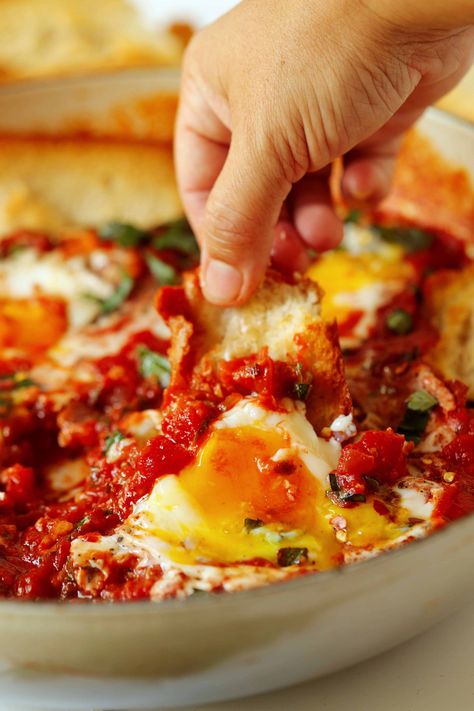 A hand dipping a piece of baguette into a pan of Eggs In Purgatory. Spicy Breakfast, Eggs In Purgatory, Brunch Sides, Italian Chopped Salad, Brunch Casserole, Italian Breakfast, Spicy Tomato Sauce, Bar Food, Quick Dinners