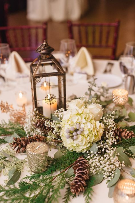 Katie warmed up her winter wedding decor with lanterns and candelabras on every table. The centerpieces also incorporated flowers from her bouquet, like hydrangeas, baby's breath, and pinecones. Pinecone Wedding Decorations, Winter Table Centerpieces, Christmas Wedding Centerpieces, Winter Table Decorations, Winter Wedding Table, Winter Wedding Centerpieces, Boda Diy, Winter Centerpieces, Wedding Adventure