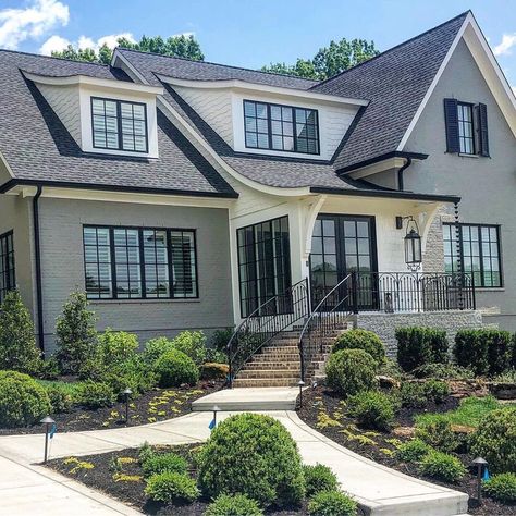 Gray painted brick with black windows and look at that roof line ... 🤩 Note on the second photo the white board and batten garage out back.… Brick House With Black Windows, Brick House With Black Trim, Gray Painted Brick House, House With Black Windows, House With Black Trim, Grey Painted Brick, Black Windows Exterior, Grey Brick Houses, Grey Exterior House Colors