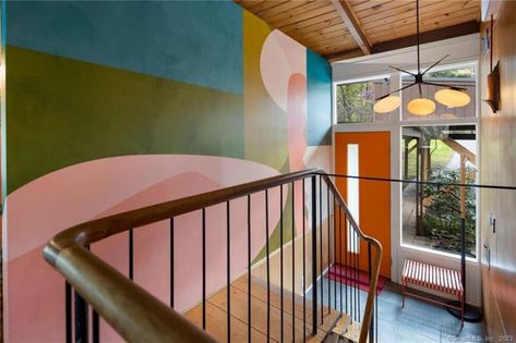 stairway area with mural/graphic painted on wall, orange front door, wood ceiling, windows Stairs Front Door, Orange Front Door, Plywood Wall Paneling, Wall Orange, Front Door Wood, Bloomfield Homes, Lime Green Walls, Orange Front Doors, Modern Homes For Sale