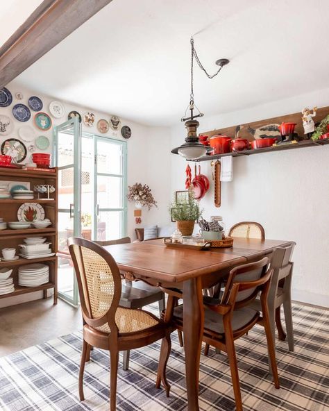 Sala de jantar integrada com cozinha, piso cimento queimado, parede branca, mesa de jantar de madeira antiga, cristaleira de madeira, poltrona de couro envelhecido, decoração vermelha, tapete xadrez, mesa redonda metálica, frigobar vermelha, cadeira de madeira, prato de parede, paneleiro antigo, luminária retrô, decoração colorida, cozinha azul e vermelha, prateleira branca. Casa de Vila Alugada com Várias Soluções | Casa de Valentina | Ph: Monica Assan | #decor #decoração #arch #arquitetura British Colonial Decor, Small House Interior, Casa Vintage, Colonial Decor, Chic Living, House Goals, Bohemian Decor, Open House, Boho Decor