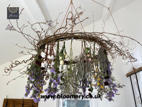 This floral chandelier would look amazing in a marquee or teepee for an enchanting and romantic wedding breakfast.  The flowers used in this design will dry over time and still look beautiful. Dried flowers will add a vintage, bohemian feel to any wedding. The flowers used are red roses, white roses, pink roses, lavender, statice, limonium, craspedia, cotton, hazel, contorted hazel. The colour palette used is dusty lilac and pink with a pop of colour from the deep red roses and yellow craspedia. Dried Flower Chandelier, British Flowers, Flower Chandelier, Floral Chandelier, Event Flowers, Dried Floral, The Cotswolds, Garden Art Sculptures, Rustic Garden Decor