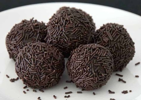 Brigadeiro - Brazilian Chocolate Truffle Fudge Balls -- Brigadeiros are a favorite dessert treat in Brazil. You can find them in stores, restaurants, vendor carts on the street and in homes throughout the country. These lovely chocolate truffles are sweet perfection in three simple ingredients.  There are several variations of Brazil’s beloved truffle, but the most common preparation being a cocoa truffle rolled into 1 1/2″ balls and covered with chocolate sprinkles. Cream Cheese Condensed Milk, Brazilian Food Recipes, Brazilian Food Traditional, Chocolate Caramel Candy, Fudge Balls, Truffle Recipe Christmas, Brigadeiro Recipe, Brazilian Chocolate, Brazilian Desserts