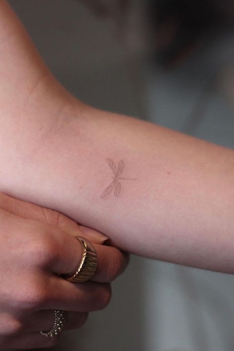 40 Awesome Dragonfly Tattoo Design Ideas Wrist Tattoos Dragonfly, Cool Fineline Tattoo, Minimalistic Dragonfly Tattoo, Dragonfly Tattoo Aesthetic, Tiny Dragon Fly Tattoo, Dragonfly Wings Back Tattoo, Dragonfly Tattoo Forearm, Brown Fine Line Tattoo, Mini Dragonfly Tattoo