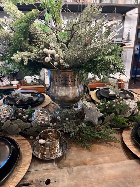 A large pewter champagne ice bucket is the centerpiece of this beautiful table Champagne Bucket Christmas Decor, Ice Bucket Decor, Ice Bucket Ideas, Outdoor Table Centerpieces, French Country Christmas Decor, Bucket Decor, Silver Ice Bucket, Christmas Booth, French Country Christmas