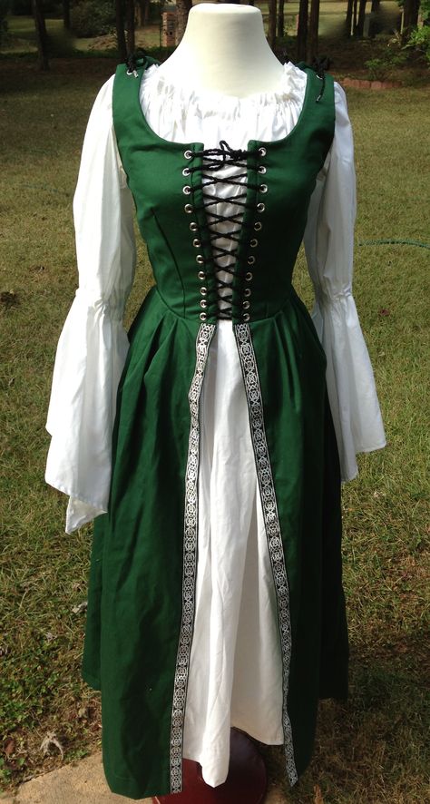 This is one of our Cotton Irish Overdresses with the Celtic Nordic Black and Silver trim added on the skirt. It is machine washable and shown with the white muslin chemise with bell sleeves. Lovely! We also make this is other colors. Irish Traditional Dress, Irish Fashion Women, Traditional Irish Clothing, Medieval Costume Women, Celtic Dress, Irish Dress, Pirate Dress, Celtic Clothing, Theater Costumes