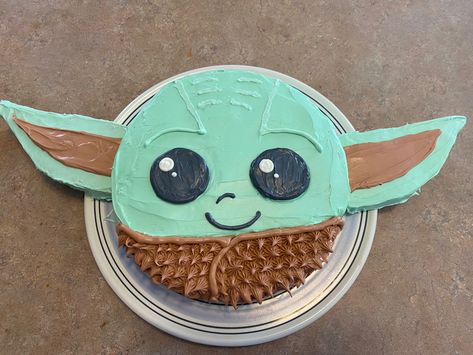 For the ears, I used rice crispy treats & put them on popsicle sticks, iced the rice crispy treats, & stuck them in the cake. I used the bottom of a kids cup to imprint a circle on the icing to make the eyes nicely circular. Yoda Birthday Cakes, Yoda Cupcake Cake, Star Wars Yoda Cake, Easy Yoda Cake, Yoda Party Food, Starwars Cake Simple, Grogu Birthday Party Ideas, Grogu Cake Ideas, Baby Yoda Smash Cake