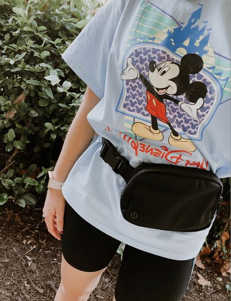 Disney World t-shirt with biker shorts and fanny pack Lululemon Belt Bag Outfit Disney, Athleisure Outfits Disney World, Bike Shorts Disney Outfit, Oversized Disney Shirt Outfit, Disney Biker Shorts Outfit, 90s Disney Outfits, Disney Athletic Outfits, Disney Park Outfit Summer, Disney World Outfits Fall