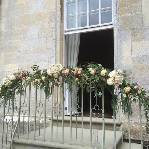 Flower and foliage garland on the railings at Elmore Court by JennyFleur Flowers On Railing, Railing Flower Decoration, Railing Decorations For Wedding, Banister Wedding Decorations Railings, Staircase Garland Wedding, Railing Floral Decor Wedding, Event Showroom, Floral Bannister Wedding, Parisian Flowers