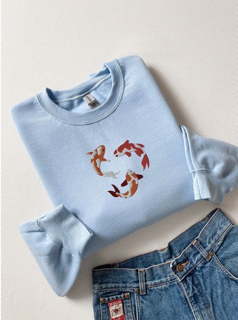 Cozy up in this soft and stylish sweatshirt featuring an embroidered koi fish design. Perfect for a day out or a night in, this sweatshirt is sure to become a favorite. #koifish #sweatshirt . #Koi_Fish_Shirt #Marine_Motifs #Shark_Sweatshirt #Japanese_Koi_Fish Koi Fish Shirt, Shark Sweatshirt, Japanese Koi Fish, Fish Shirt, Japanese Koi, Shark Shirt, Embroidered Crewneck, Embroidered Clothes, An Article