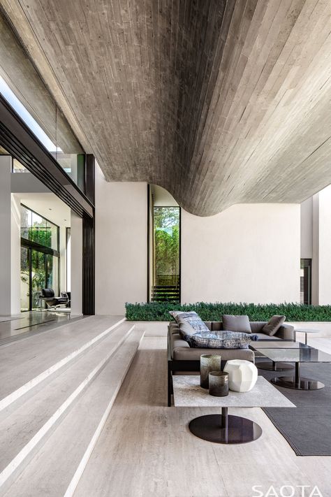 The main living areas of this modern house step down to the landscaped terrace. Throughout the home, vein cut Travertine floors have been featured, while the ceiling features a wavy concrete element. #ModernHouse #ConcreteCeiling #TravertineFloors Interior Mansion, Contemporary Outdoor Living, Concrete Ceiling, Houses In France, Timber Ceiling, Travertine Floors, Clerestory Windows, Open Living Room, Open Space Living