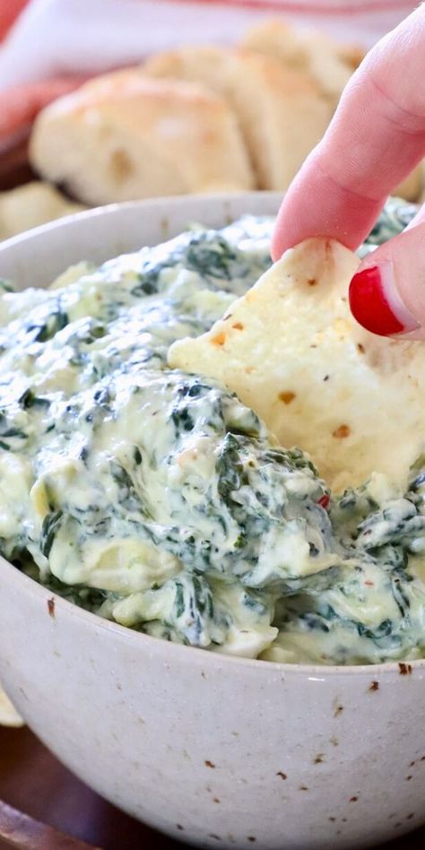 spinach artichoke dip in a bowl with a tortilla chip dipped into the dip Cold Spinach Artichoke Dip, Classic Spinach Dip Recipe, Appetizers Slow Cooker, Homemade Spinach Dip, Easy Spinach Artichoke Dip, Easy Spinach Dip, Classic Spinach Dip, Vegan Spinach Dip, Potluck Meals