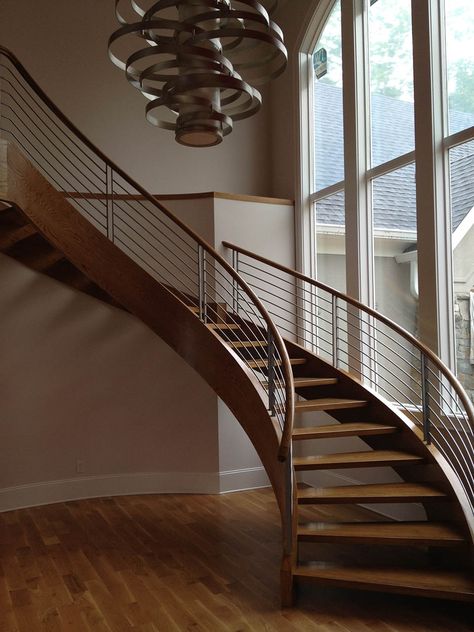 Sleek and modern wooden curved staircase with cable railings. درابزين السلم, Round Stairs, Steel Railing Design, Circular Stairs, Concrete Staircase, Staircase Design Modern, Staircase Railing Design, Staircase Ideas, Stair Railing Design