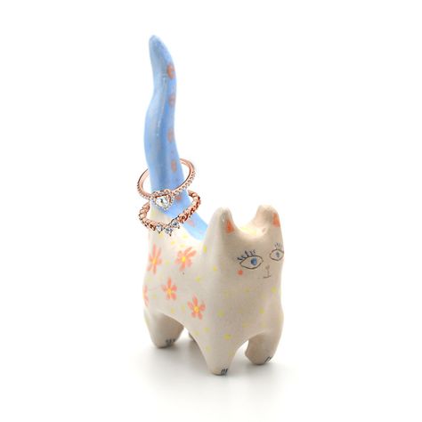 This piece showcases a hand-painted cat with a serpent, moon cycles, stars, and flowers. Made from ceramic, it's crafted by Eva Boch with care. This cat is a beautiful reminder of feminine energy and mystical power, and is perfect for holding rings. Its unique energy will enhance any space it inhabits with magic and beauty, accompanying you throughout your daily life. * Size: 14cm hight * Designed in Barcelona. * Ceramic * Glazed * Hand-signed by the designer * Made to order within 7 days All or Ring Holder Ceramic, Ring Holder Diy, Stars And Flowers, Chat Diy, Cat Ring Holder, Painted Cat, Hand Painted Cat, Clay Crafts Air Dry, Moon Cycles