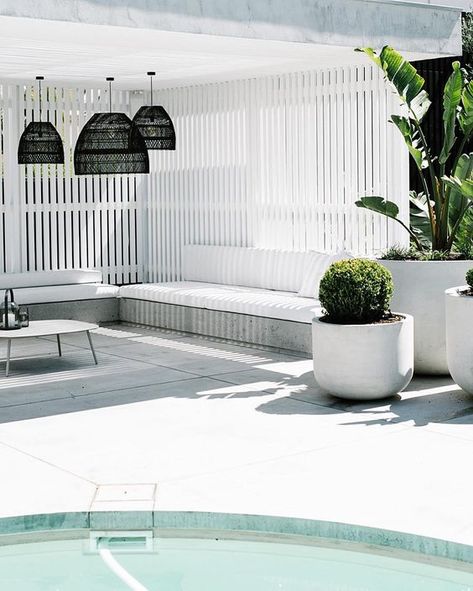 a minimalist white pool cabana with black pendant lamps, simple wooden benches with upholstery, potted plants and a coffee table Pool Gazebo, Pool Pergola, Pool Cabanas, Living Pool, Outdoor Pool Area, Pergola Ideas, Pool Landscape Design, Pool Cabana, Casa Exterior