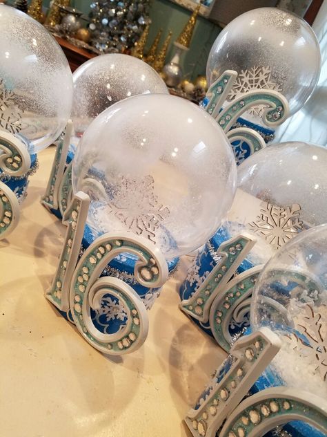 I used acrylic light covers and boxes from the dollar store to create these snowglobe centerpieces. A little sprinkle snow and spray snow added the final touch!  added some snowflake and small silver tinsel to add that winter Wonderland touch. Winter Wonderland Sweet 16 Decorations, Diy Decorations Party, Winter Wonderland Quince, Winter Wonderland Sweet 16, Quinceanera Winter Wonderland, Quince Decorations Ideas, Winter Wonderland Quinceanera, Spray Snow, Sweet 16 Winter Wonderland