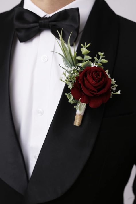 Beautiful wine red rose boutonniere with some greenery and twine wrapped stem. Simple and elegant boutonniere for your groom. Boutineer Ideas Burgundy, Groomsmen Boutonniere Burgundy, Wine Red Centerpieces Wedding Ideas, Burgundy Rose Bridal Bouquet, Wine Red Roses Bouquet, Red September Wedding, Deep Red Boutonniere, Black Tie Wedding With Red Roses, Maroon Boutonniere Wedding