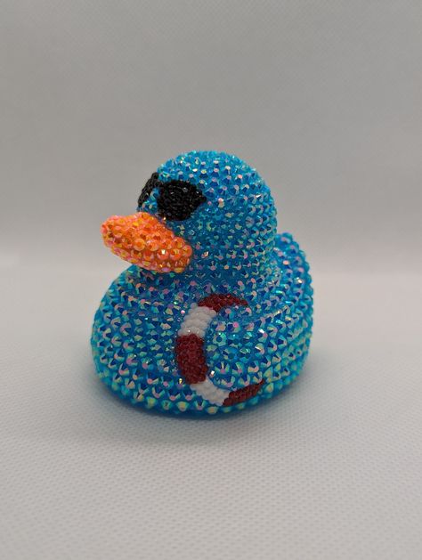 Summertime rhinestone rubber duck. A perfect gift for yourself or your favorite off-road enthusiast! Each rhinestone is hand-placed. Duck is approximately 2.75 in. x 2.75 in. You may notice an odor coming from the duck. It is from the extra-strength glue used to place the rhinestones. Leave the duck in a well-ventilated area, and the smell will dissipate in a few days. *If you plan to keep the duck in a vehicle, keep an eye on it when it is hot outside. Rubber ducks are known to melt or misshapen in hot temperatures. NOT A TOY. CONTAINS SMALL PARTS. NOT INTENDED FOR CHILDREN. NOT FOR USE IN WATER. Bedazzled Rubber Ducks, Duck Things, Rubber Duckies, Rhinestone Projects, Hot Outside, Bling Crafts, Duck Art, Rubber Ducks, Custom Air Force 1