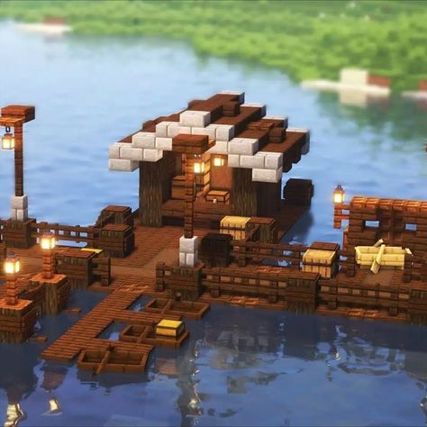 Do you enjoy fishing and boating? Then this build is a must-have in your survival world! The primary material used in this build is dark oak wood, with highlights using stones and different cuts of dark oak wood for the details. It is small but complete with utilities. Fishing platform, a boat dock, and a house! Following the tutorial, you can capture the tiniest of details in this intricate fishing dock! Test it now! Dock House Ideas, Minecraft Floating House, Minecraft Houses On Water, Minecraft Dock House, Minecraft Fishing House, Minecraft Fishing Hut, Minecraft Fishing Dock, Minecraft Dock, Fishing Platform