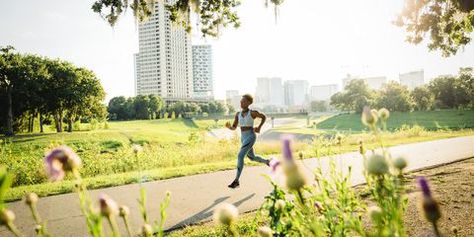 Mixed Race woman running on path in park beyond wildflowers Running Path Landscape, Running Portrait Photography, Race Pictures Running, Mixed Race Woman, 10k Training Plan, Beginner Half Marathon Training, 10k Training, Half Marathon Training Schedule, Training For A 10k