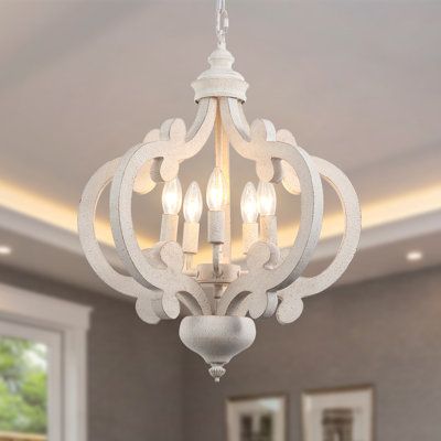 As much a work of art as a lighting fixture, this French country chic chandelier elevates the look of any room in your home, from the dining room to the entryway. This eye-catching lantern design is crafted from metal and wood and features ornate C-shaped accents that fan out around the center bulbs. It’s finished in a neutral, whitewashed hue for an antique-inspired look, and accommodates five bulbs of up to 60W (not included) each around its candelabra base. Finish: Antique Whitewashed | Ophel Wooden Chandeliers, French Country Chandelier, Country Chandelier, Retro Chandelier, Ceiling Types, Cottage Lighting, Rustic Pendant Lighting, Hanging Ceiling Lamps, Wooden Chandelier