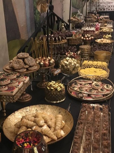 This was a huge dessert table for a construction company’s 50th anniversary celebration! It was 3, 8 foot tables of bumper to bumper delicious deserts and black and gold displays! What a sight to behold!! Gold And Black Dessert Table, Black And Gold Dessert Bar, Gold And Black Candy Table, Black Gold Silver Dessert Table, Black And Gold Desert Bar, Gold Dessert Table, Refreshments Table, Mediterranean Desserts, Black Dessert