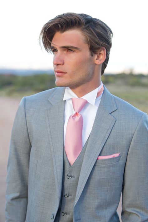 That jawline though 😍😍  Ladies,  get your groom looking their best in this grey suit by Allure Men.  Check out the link to browse more grey, you're sure to find the perfect look 😃 White Suit Pink Tie, Grey And Pink Suit, Suits With Pink Ties, Grey Suit Pink Tie, Grey Suit Black Shirt, Charcoal Suits, Pink Bridesmaid Dresses Short, Grey Tux, Pink Shirt Men