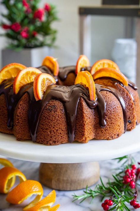 cranberry orange bundt cake with chocolate ganache on top, and dried orange slices on top, with an orange peal beside it Cranberry Orange Bundt Cake Recipe, Chocolate Cranberry Cake, Cranberry Orange Bundt Cake, Moist Lemon Pound Cake, Orange Peal, Baked Gifts, Infused Chocolate, Orange Bundt Cake, Photography References