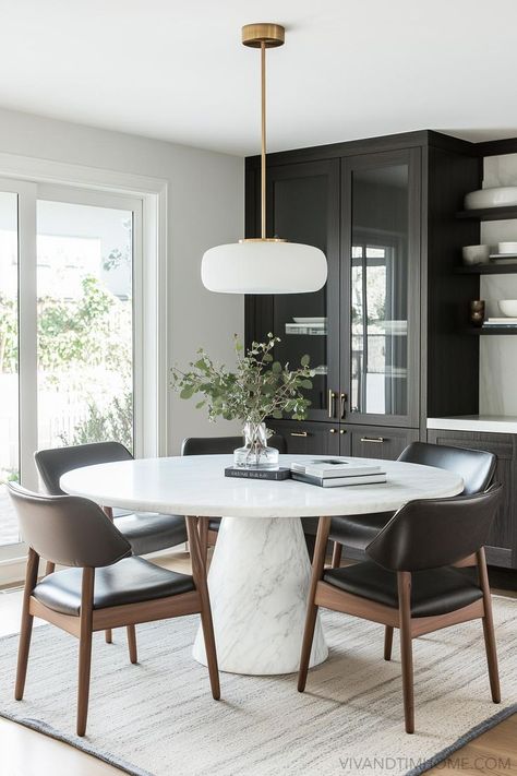 Moody dark dining room decor with white round table dining and modern dining chairs Dark And Moody Dining Room, Formal Dining Room Design, Moody Dining Room Ideas, Marble Dining Table Decor, Black Dining Room Decor, Dining Room Design Round Table, Modern Round Dining Room Table, Dining Table Decor Everyday, Moody Dining Room