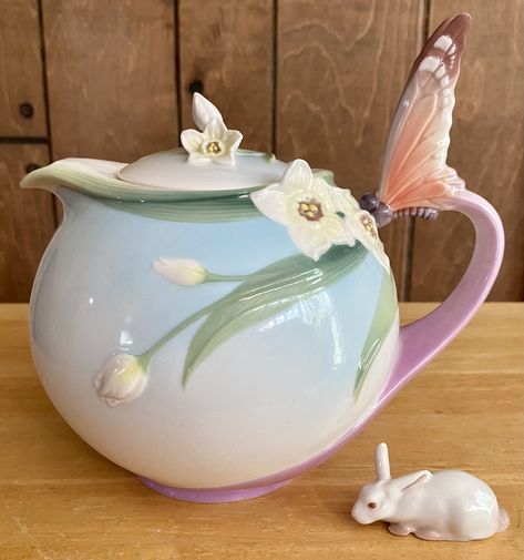 This porcelain teapot was designed by Jen Woo for the Franz Collection, Inc. It's round with a blue fading to white where it meets the orchid color base that curves out and up to form the handle which has a beautiful coral butterfly on the top. Model no. XP1878 is decorated with pale yellow narcissi and graceful stems and leaves wrapping around the top of the teapot. It has a narcissus and bud finial. It is marked with the Franz logo, Jen Woo’s signature, the model no and “Made in China”. Coral Butterfly, Franz Collection, Orchid Color, The Orchid, Porcelain Teapot, Pale Yellow, Top Model, Finials, Tea Time