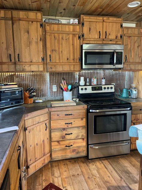 Rustic meets industrial in this kitchen. Pictured: Galvalume ceiling tiles. Farmhouse Kitchen Rustic Cabinets, Rustic Kitchen Cupboard Doors, Kitchen Cabinet Rustic Farmhouse Style, Galvalume Ceiling, Rustic Pine Kitchen Cabinets, Barn Tin Kitchen Island, Burnt Wood Cabinets, Rustic House Remodel, Corrugated Metal Wall Kitchen