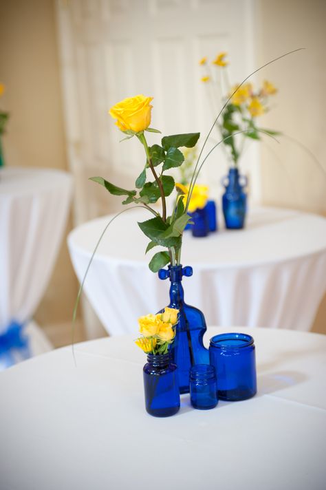 blue bottles yellow flowers centerpieces wedding Cobalt Blue And Yellow Wedding, Wedding Cake Royal Blue, Cake Royal Blue, Royal Blue And Yellow Wedding, Yellow Flower Centerpieces, Yellow Wedding Bouquets, Yellow Blue Wedding, Blue And Gold Party, Flowers Centerpieces Wedding