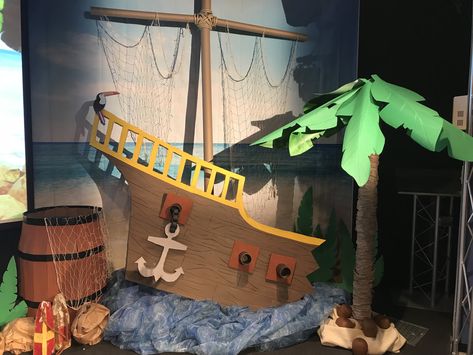 Shipwrecked VBS 2018 stage decorations - my palm tree from a carpet tube, umbrella and corobuff paper, ship made of foam board and a diy barrel from a cardboard box. Diy Shipwreck Decor, Scuba Vbs Stage Decorations, Cardboard Shipwreck, Peter Pan Diy Decorations, Pirate Theme Vbs, Shipwreck Vbs Decorations, Shipwreck Diy, Diy Shipwreck, Pirate Vbs Decorations