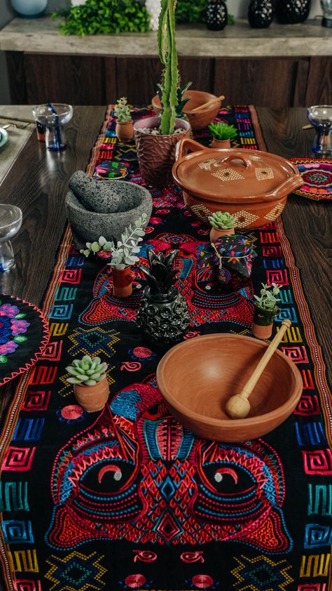 Mexican table setting featuring colorful embroidered textiles, clay pots, a stone mortar and pestle, succulents, and wooden bowls, creating a warm and authentic atmosphere. Mexican Tables, Mexican Table Decor, Mexican Table Setting, Embroidered Textiles, Mexican Table, Dinner Setting, Mexican Dinner, Rustic Pottery, Private Chef