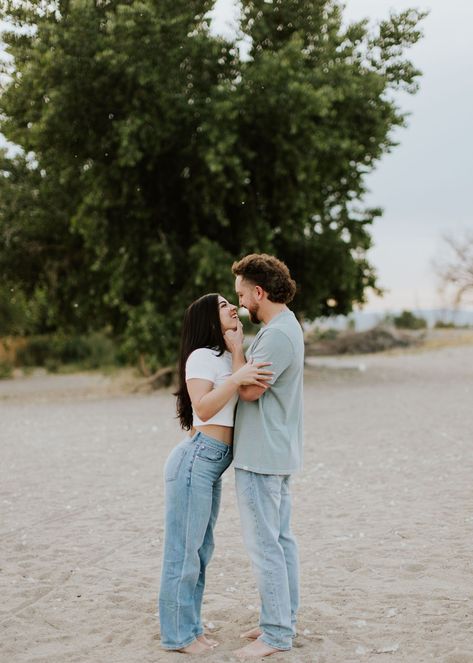 Utah based engagement photographer takes photos of a newly engaged couple in a field in the mountains showing her wearing a white tshirt and blue jeans and him in soft grey tshirt and jeans.    #utahengagementphotographer #travelengagementphotographer #engagementoutfitideas #engagementphotooutfits #coupleposingideas White Tee And Jeans Photoshoot Couple, White Tshirt Photoshoot Couple, White And Denim Engagement Photos, White Tee And Jeans Engagement Photos, Engagement Photos Blue Jeans White Shirt, White Shirt Blue Jeans Couple Photoshoot Beach, White Shirt And Blue Jeans, Mum Jeans, Romantic Couple Poses