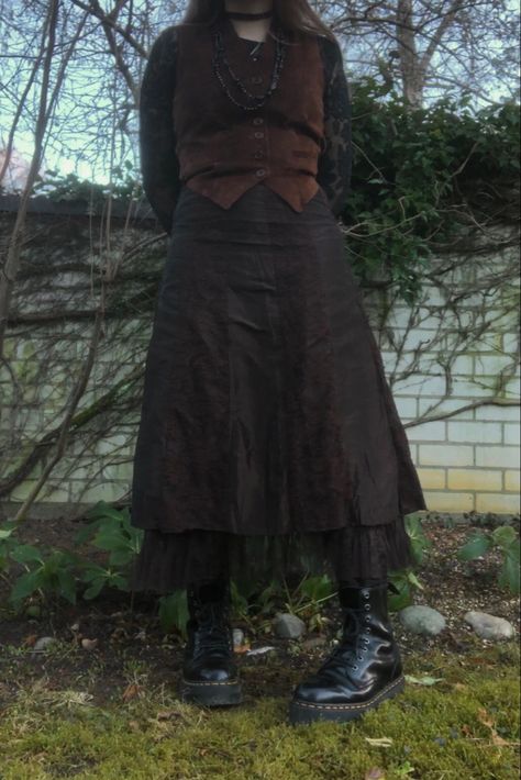 A mid-size person/girl wearing a brown waistcoat with a wide black lace long sleeve underneath, a brown wide maxi witch skirt, platform dr. Marten shoes and multiple crystal rings and bracelets. The person is also wearing multiple silver necklaces, one in form of a butterfly, a thrifted black bead necklace and a black lace choker. Fit Aesthetic Outfit, Long Black Skirt Outfit, Dark Cottage Core, Fairycore Dark, Fit Aesthetic, Geeky Clothes, Black Skirt Outfits, Grunge Fairycore, Style Bundle