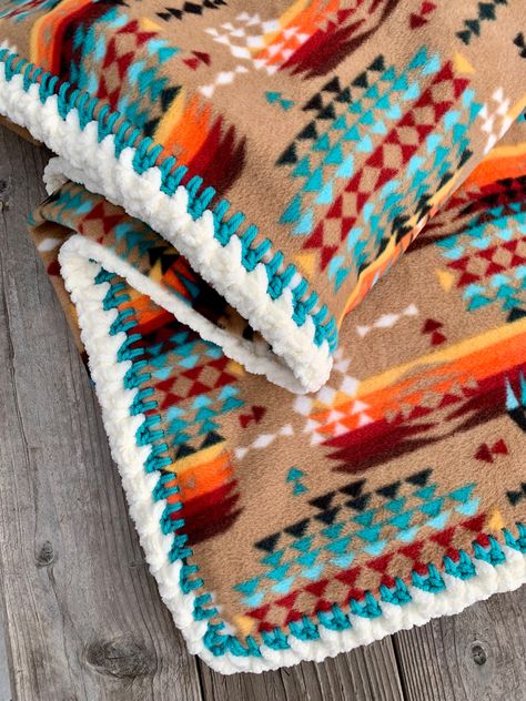 This Crochet Edge Native American Style Fleece Blanket is crafted with our top-quality fleece and an artisanally hand-stitched crochet edge by April. Enjoy the soft and fluffy comfort of fleece while adding a classic native design to your home. Available in four different edge options:1. Serged Edge2. Hemmed Edge3. Crochet Blanket Stitch4. Deluxe Crochet StitchApproximate Sizes (hemmed sizes are a bit smaller):BABY 30"x 38"MEDIUM 52" x 60"LARGE 72" X 60"PERSONALIZATIONYou may personalize your blanket. I screen print your name choice (two words maximum) in font style #1 on my reproduction grain sack fabric. If you desire a different font, please refer to the picture showing font styles and specify the style number along with the name in the notes upon checkout.BLANKET CAREWash and dry on de Native American Blanket Pattern, Western Crochet Blanket, Crochet Blanket Edges Ideas, Southwest Style Living Room, Fleece Blanket Ideas, Fleece Blanket Edging, Western Crochet, Native American Inspired Fashion, Native Blanket