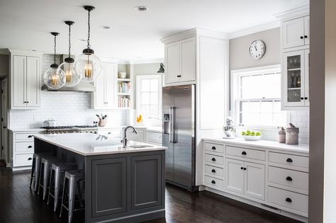 White and gray kitchen features white cabinets adorned with bronze cup pulls and knobs paired with white quartz countertops and a white subway tile backsplash. Grey Island, Gray Island, Grey Kitchen Island, House Farm, White Kitchen Remodeling, White Kitchen Design, Kitchen Farmhouse, Transitional Kitchen, Grey Kitchens