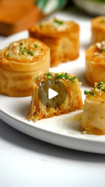 Nadia Aidi on Instagram: "Gruyere & Honey Phyllo Bites ❤️ they are so good + easy to make! These yield 12 bites!  Ingredients:  * 1-8oz package phyllo (Athens) * 8 oz gruyere (always Emmi). * 6 oz melted unsalted butter (Kerrygold). * 3 tbsp chives (chopped). * 1/4 cup chopped toasted almonds. * Honey to taste (about 1/2-1 tbsp per bite).  Directions: 1. Take 1/2-1/3 of the phyllo sheets and roll the rest in the plastic wrap to save. 2. Add some melted butter in between a couple of the filo sheets. I did about 2-3 tbsp of melted butter. 3. Add the grated gruyere to the phyllo sheet, all across. 4. Roll it up really tightly. 5. Slice into 12 rounds with a sharp knife. 6. Add 1/2 tbsp of butter to the bottom of a 12 muffin tin.  7. Add the filo bites onto the muffin tin and add 1/2 tbsp butt Phyllo Triangle Appetizers, Apple Phyllo Recipes, Filo Pastry Appetizers, Recipes Using Phyllo Dough, Filo Pastry Recipes Sweet, Phyllo Dough Recipes Appetizers, Phyllo Dough Recipes Dessert, Phyllo Pastry Recipes, Filo Pastry Recipes Savoury