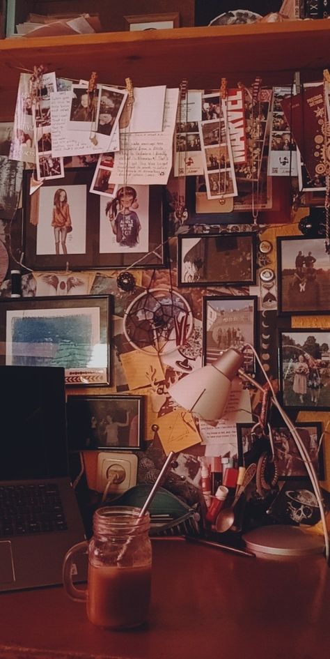 A messy work desk with the wall behind being covered by photographs and other knick knacks. On the desk there is a laptop, pencil case with everything spilling out and a lamp. In front of everything there is a mason jar filled with iced coffee and ice. Messy Table Aesthetic, Messy Background, Messy Table, Chic Dorm, Messy Bedroom, Creative Vibes, Messy People, Dormitory Room, Messy Closet