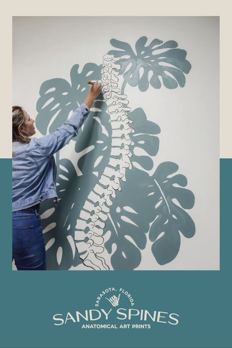 Dr. Sandy painting an anatomical skeleton with teal monstera leaves in the background on a wall of her office. Physiotherapy Room, Human Body Science Projects, Psychology Office Decor, Chiropractic Office Design, Clinic Art, Massage Room Design, Dream Home Gym, Gate City, Office Wall Design