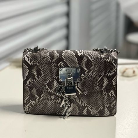 Versatile Elissa Shoulder Flap Handbag Gets A Bold New Look. Accented With A Polished Hardware And Composed Of Python-Effect Leather, This Structured Handbag With An Adjustable Shoulder Strap Balances Style And Function. Dimensions: 10.5" L X 7.5" H X 3" Wdrop: 23" (Strap)Flap With Snap Closurechain Strap Detaillogo Plate At Frontdkny Charm Detail At Front100% Polyurethaneorigin: Imported Leather Slouch Bag, Dkny Bags, Dkny Bag, Snakeskin Purse, Slouch Bags, Faux Leather Handbag, Nylon Tote Bags, Genuine Leather Purse, Brown Leather Shoulder Bag