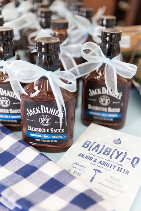 This B(A)B(Y)-Q Shower Theme Is So Cute, We Could Just Eat It Up:  "My favorite part of the shower was certainly styling all the little details," Whitmore says. "I loved the cute favor idea to give out barbecue sauce to guests as they left the party! We decided on Jack Daniels since it's a Tennessee brand! Ashley and her husband absolutely adored all the sweet details including the garland of baby pictures of both her and her husband." Bibs And Ribs Baby Shower Ideas, Baby B Que Shower Ideas, Bbq Baby Shower Ideas For Boys, Baby Que Shower Ideas, Baby Q Shower Ideas, Bbq Baby Shower Ideas, Babyque Shower, Baby Bbq, Barbecue Baby Shower