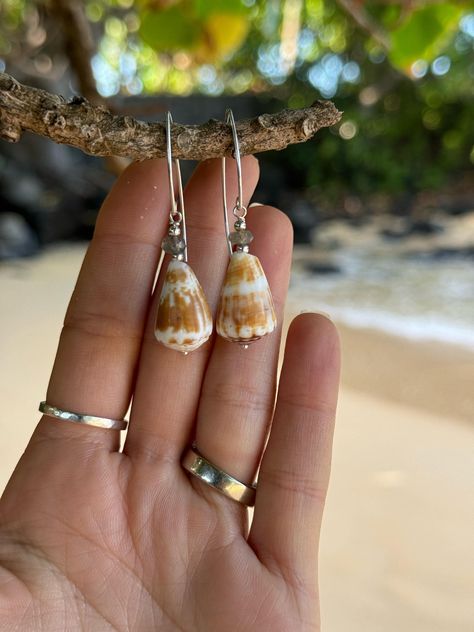 "Mexico X Kauai" Collection ✨ * Genuine & rare, handpicked cone shells off the coast of Bahia de Banderas Mexico * Your choice of 5 different cone shell style earrings in 14k gold fill. Please see drop down menu and refer to abbreviations for your choice of style. If you have any questions, please feel free to message me. Labradorite stone SS - Sterling silver Marquis ear wires with labradorite stones & cone shells (Approx. 2" in length)  14k GF beaded chain - 14k gold fill Marquis ear wires with pink Keshi pearls and cone shells (Approx. 2" in length) Moonstone tear drop - Moon stone tear drops suspended from cone shells (Approx. 2.25" in length)  Huggie hoops - 14k gold fill beaded chain with beautiful dangling cone shells (Approx.  3" in length)  Marquis pink pearl - Medium huggie hoops Shell Jewelry Ideas, Ears Ringing, Photograph Jewelry, Cone Shell, Tear Drops, Seashell Jewelry, Keshi Pearls, Shell Jewelry, Shell Crafts