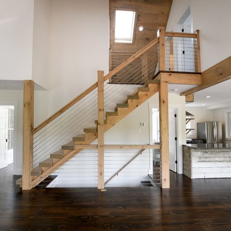 The modern, loft-like stairs in our Barn 31 home design show off a nice, light wood with steel cable railings. Stairs In A Frame House, Cabin Loft Stairs, Cabin Stairs To Loft, Barndominium Loft Railing, Barn Staircase To Loft, Open Staircase Ideas, Barn Loft Apartment, Barn Loft Ladder, Barn Bed